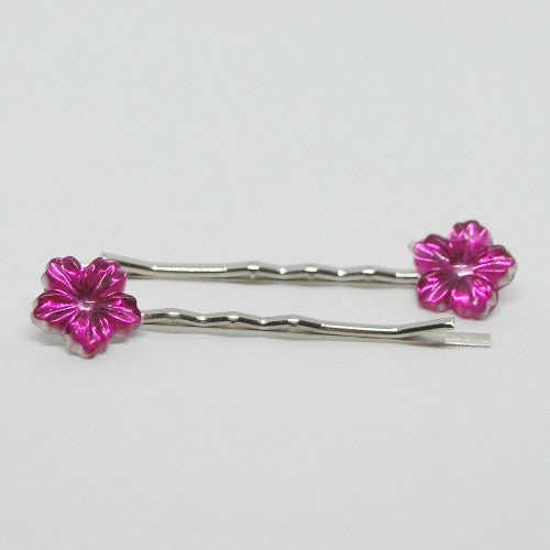 Two silver hair pins with pink flower-shaped ends on a light gray background