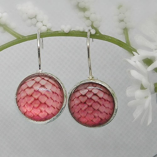 Pink patterned earrings on a white floral background