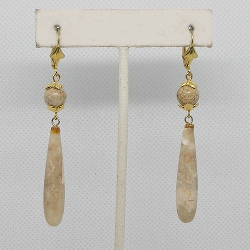 Pair of earrings with gold and beige beads on a white background
