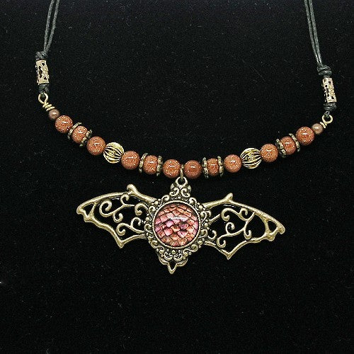 Necklace with bat pendant and beaded chain on a black background