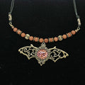 Necklace with bat pendant and beaded chain on a black background