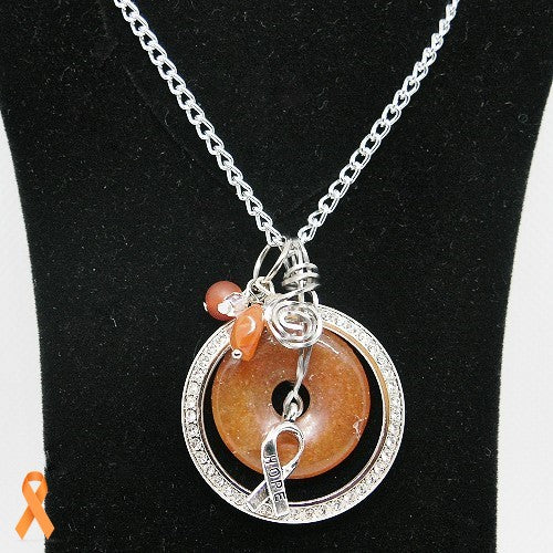 Necklace with circular pendant and orange ribbon on a black background