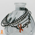 Bracelet with orange ribbon and 'hope' charm on a clear glass bottle
