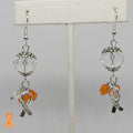 Earrings with orange and clear glass beads and Hope ribbon charms on a gray background
