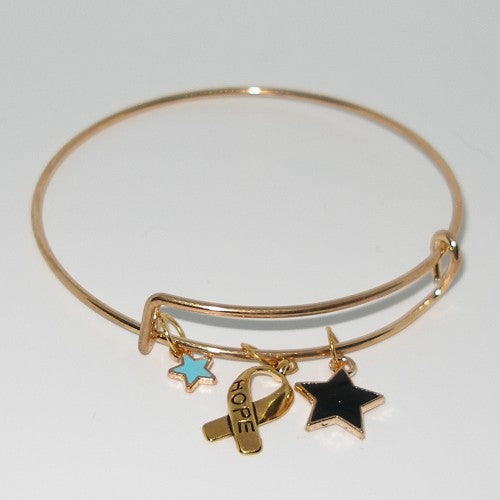 Gold bracelet with star, ribbon, and heart charm on a white background