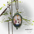 Vintage-style pendant necklace with a portrait design on a white floral background