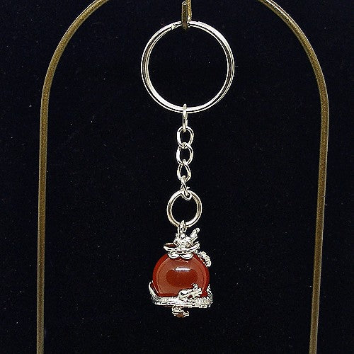 Keychain with red agate stone and silver dragon charm on a black background