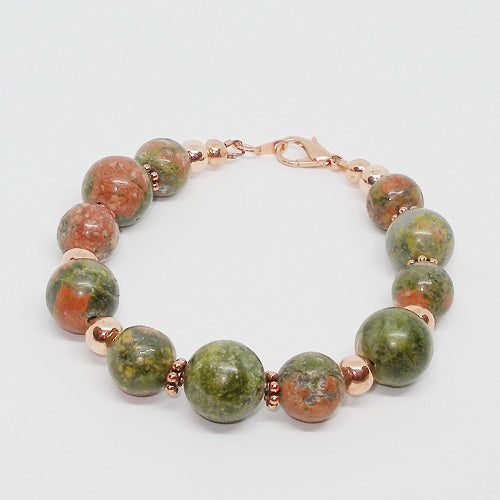 Bracelet with green and brown beaded design on a white background