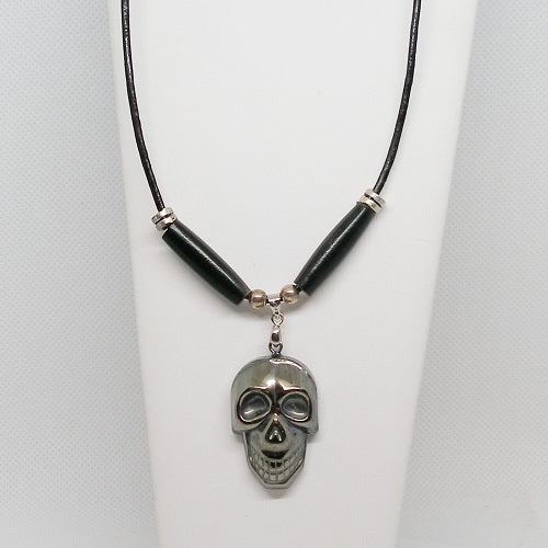 Necklace with skull pendant on a white stand