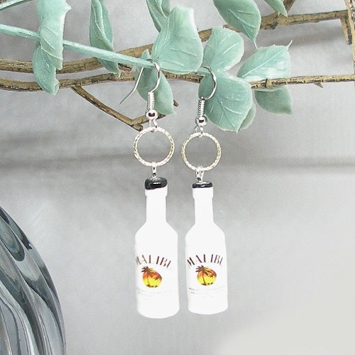 Bottle-shaped earrings hanging from a branch.