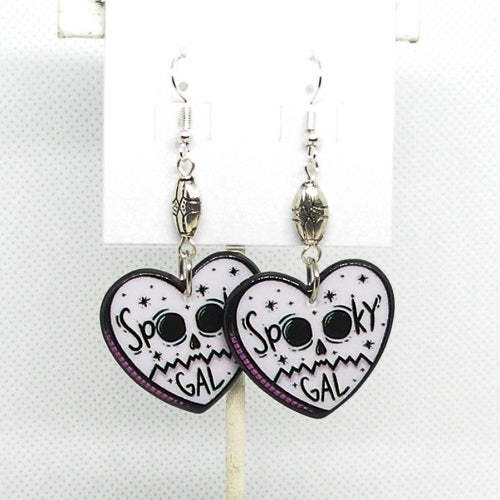 Heart-shaped earrings with skull design and 'Spooky Gal' text on a white background