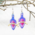 Earrings with heart and bottle design on a white background