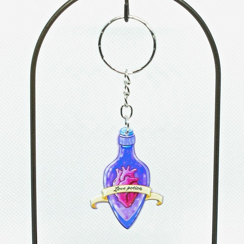 Decorative keychain with a purple bottle and heart design on a white background