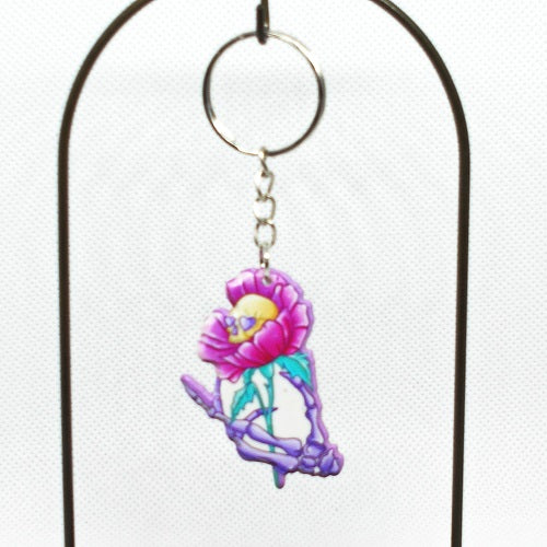 Keychain with cartoon skull inside a pink flower on a white background