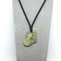 Necklace with a green Heart pendant on a gray card