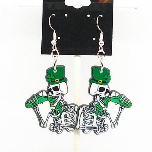 Pair of skeleton earrings with green hats and clovers on a white background