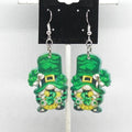 Pair of green leprechaun gnome earrings on a white background