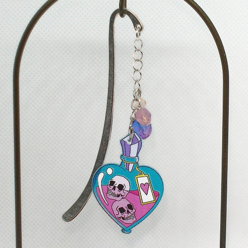 Metal bookmark with skull design and heart on a white background