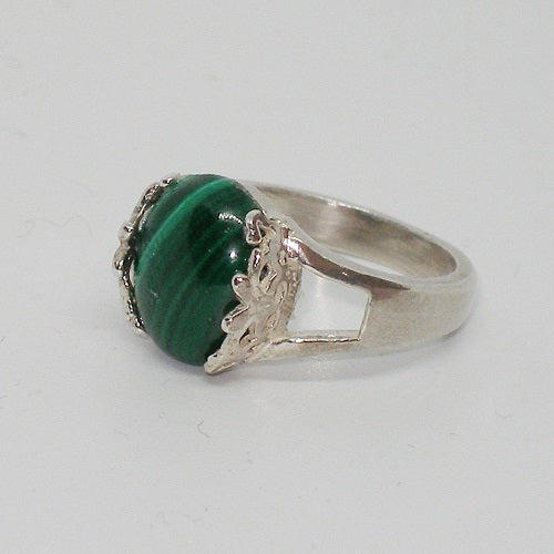 Silver ring with a green stone on a light gray background