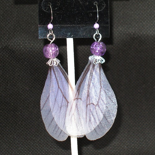 Fairy wing earrings with purple beads on a black background