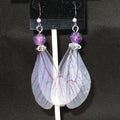 Fairy wing earrings with purple beads on a black background