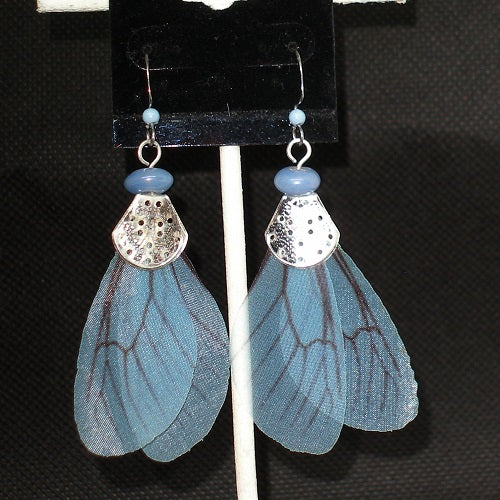 Blue fairy wing earrings with silver accents on a black background