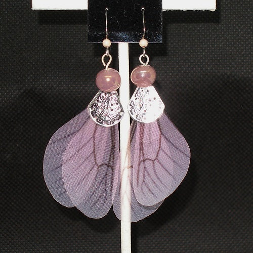 Pair of fairy wing earrings with pink  beads on a black background