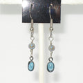 Silver earrings with light blue stones on a white background