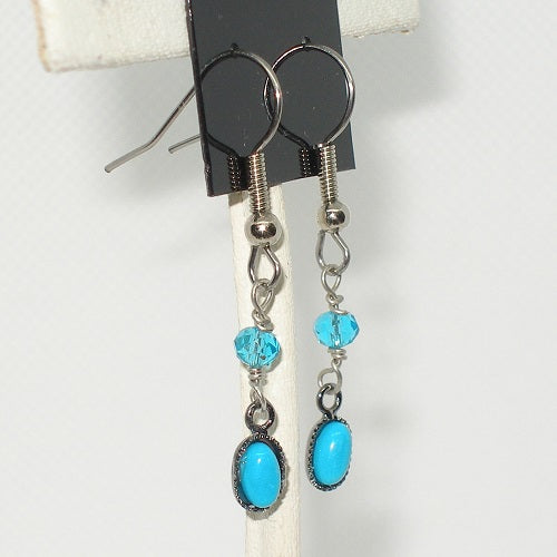 Silver earrings with turquoise beads on a white background