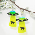  UFO earrings with green and black details on a white background