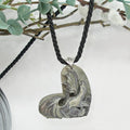 Necklace with a carved heart-shaped stone pendant on a white background
