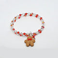 Bracelet with red and clear beads and a gingerbread man charm on a white background