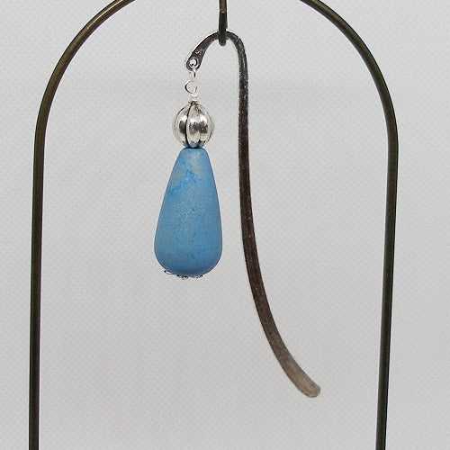 Metal bookmark with blue teardrop and silver bead on a white background