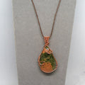 Necklace with a teardrop-shaped pendant featuring a natural stone design on a gray background