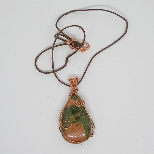 Necklace with a green stone pendant on a white background