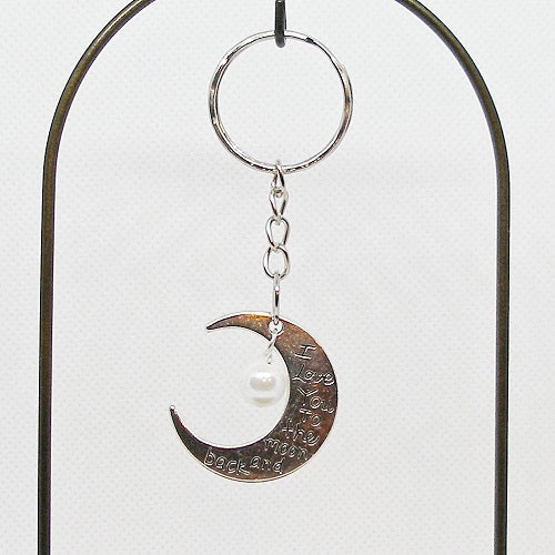 Silver crescent moon keychain with a pearl on a white background