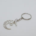 Silver keychain with moon design and pearl, on a white background