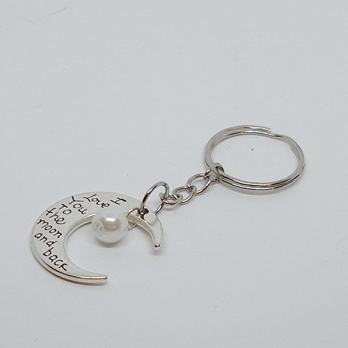 Silver keychain with moon design and pearl, on a white background
