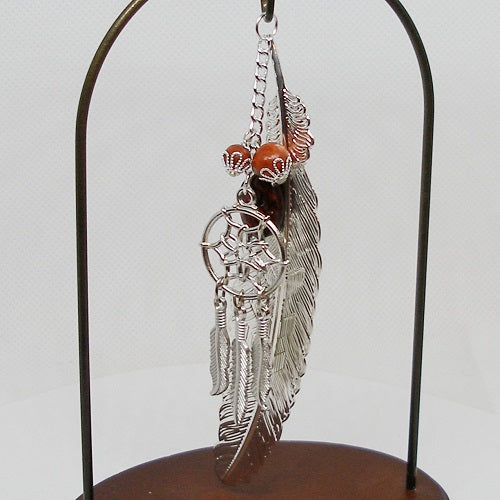 Silver feather bookmark and dreamcatcher dangle on a stand with a white background