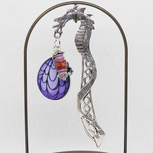 Decorative dragon bookmark with purple and red accents on a white background