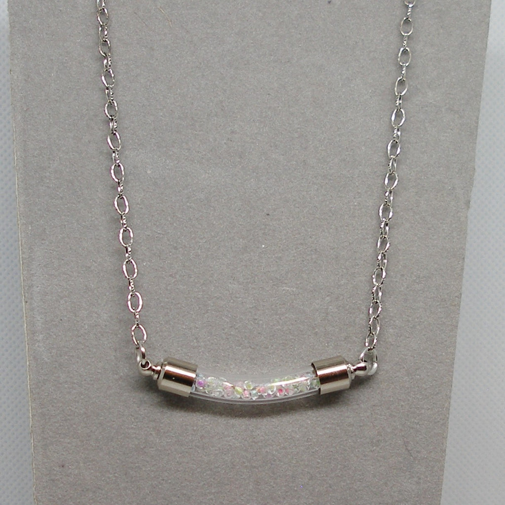 Silver necklace with a bar pendant on a gray card