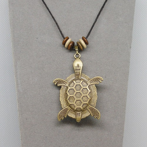 Bronze turtle pendant necklace with honeycomb pattern on a gray card