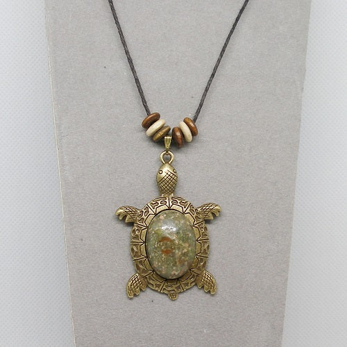 Necklace with stone turtle pendant and beads on a gray background