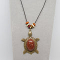 Necklace with stone turtle pendant and colorful beads on a gray background