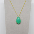 Necklace with a green teardrop pendant on a gray card