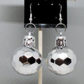 Silver faceted ball earrings on a gray background