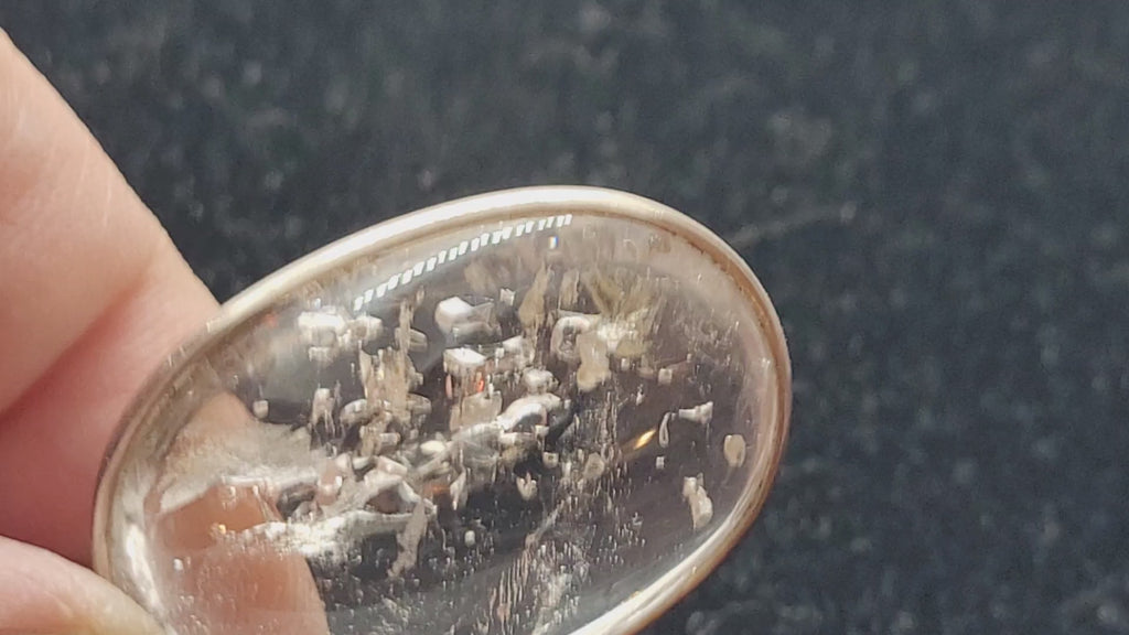 video showing moving bubble in enhydro quartz pendant with a black background
