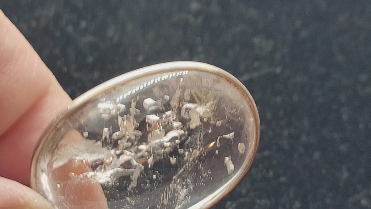 video showing moving bubble in enhydro quartz pendant with a black background